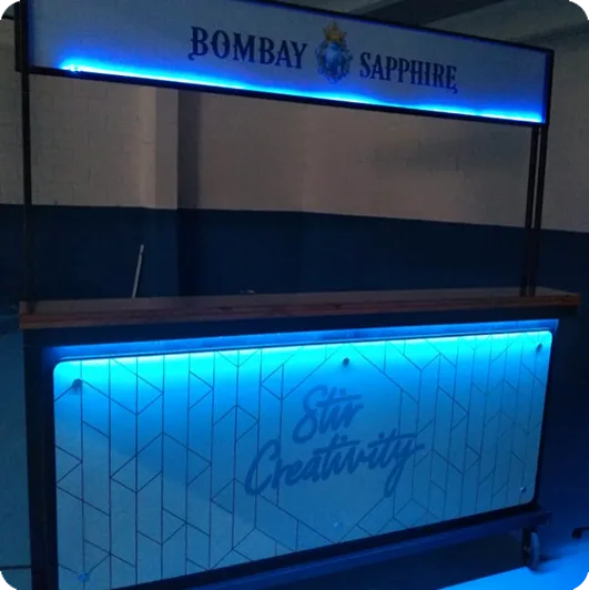 Bar da Bombay Sapphire com painel retroiluminado da campanha Stir Creativity
