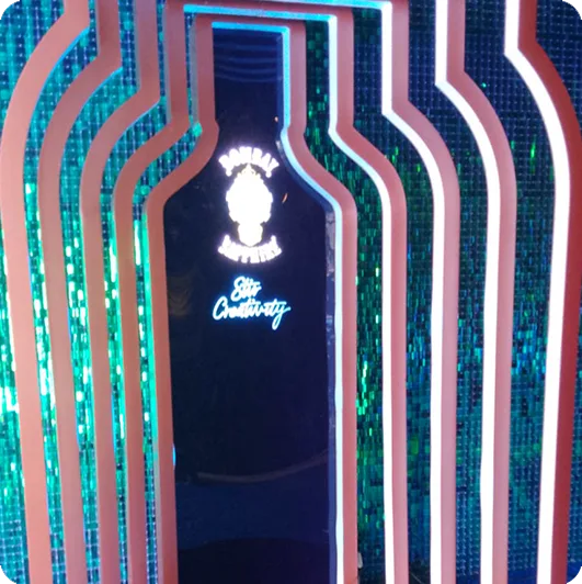 Cenografia de garrafa da Bombay Sapphire em painel de lantejoulas verdes
