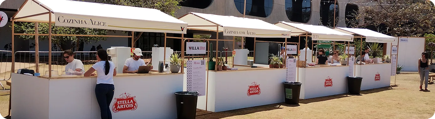Fileira de quiosques da Villa Stella Artois montados em evento a céu aberto