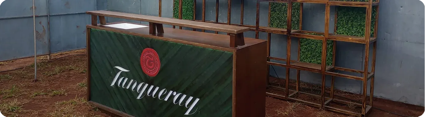 Bar de madeira da Tanqueray com painel verde e estante vazada durante a montagem