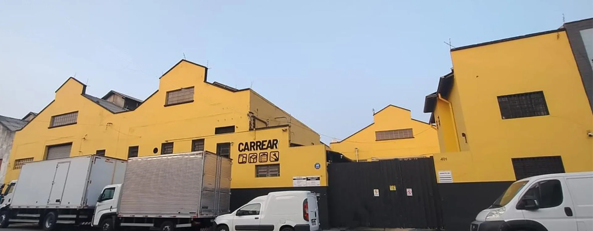 Frota estacionada em frente ao galpão amarelo da Carrear, na Mooca